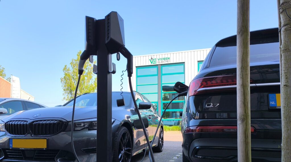 Dubbele laadpaal bij bedrijfsgebouw voor elektrische bedrijfswagens